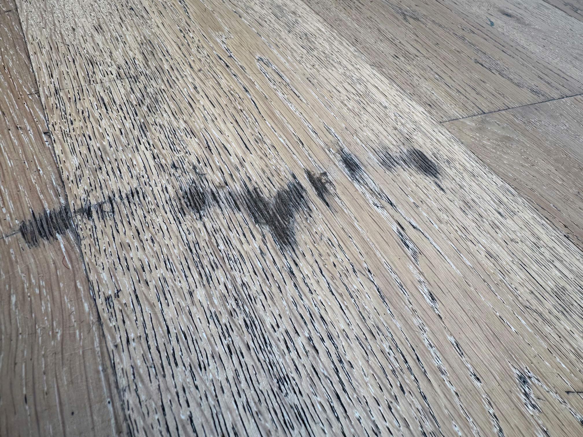 Parquet chêne blanchi vitrifié qyui présente des zones noires liées à l'usure